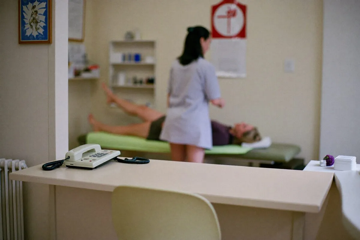 Leerer Empfangstresen einer Physiotherapie-Praxis, das Telefon klingelt — die Behandlerin ist beim Patienten.